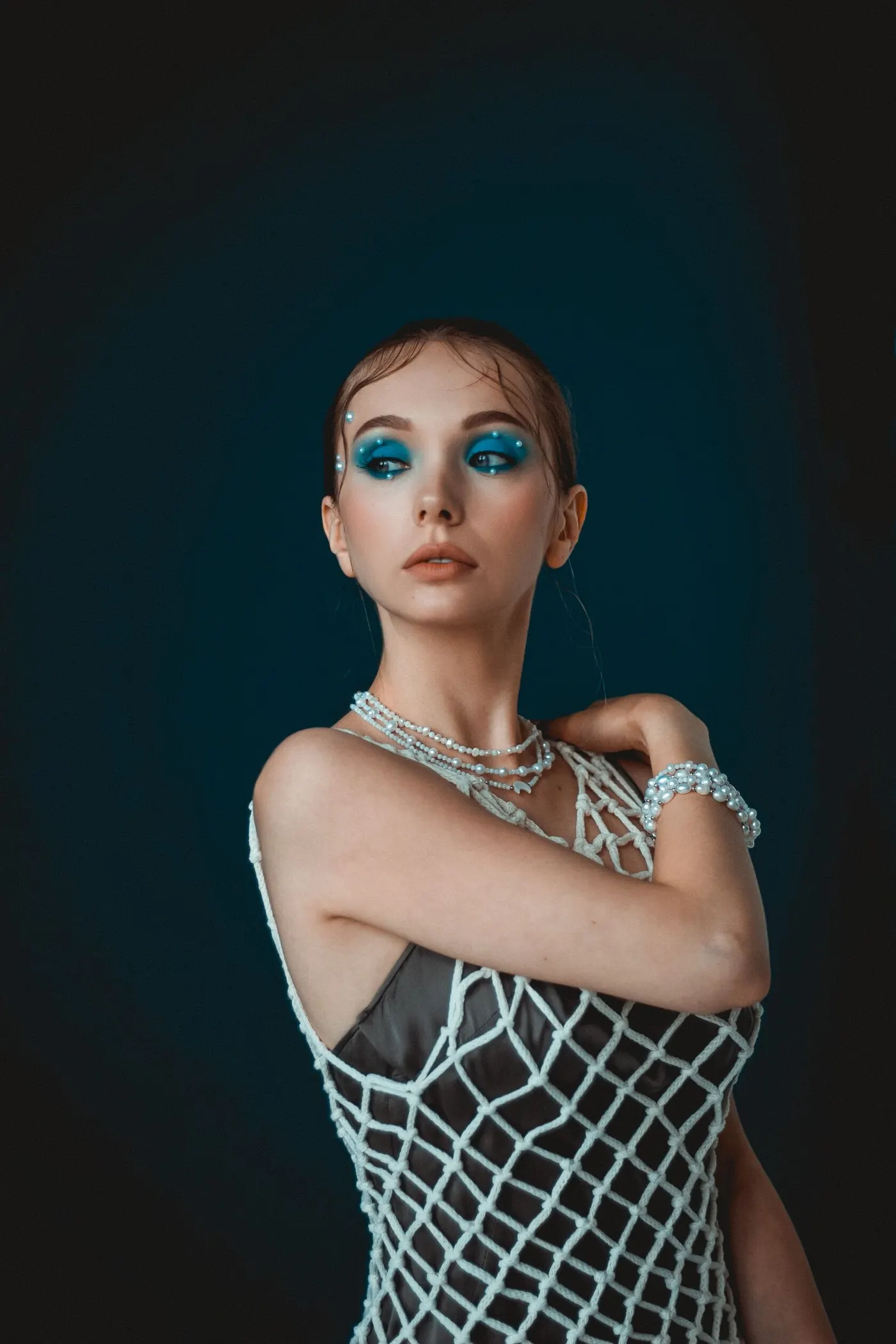 Fashion portrait with vivid blue makeup and pearl jewelry