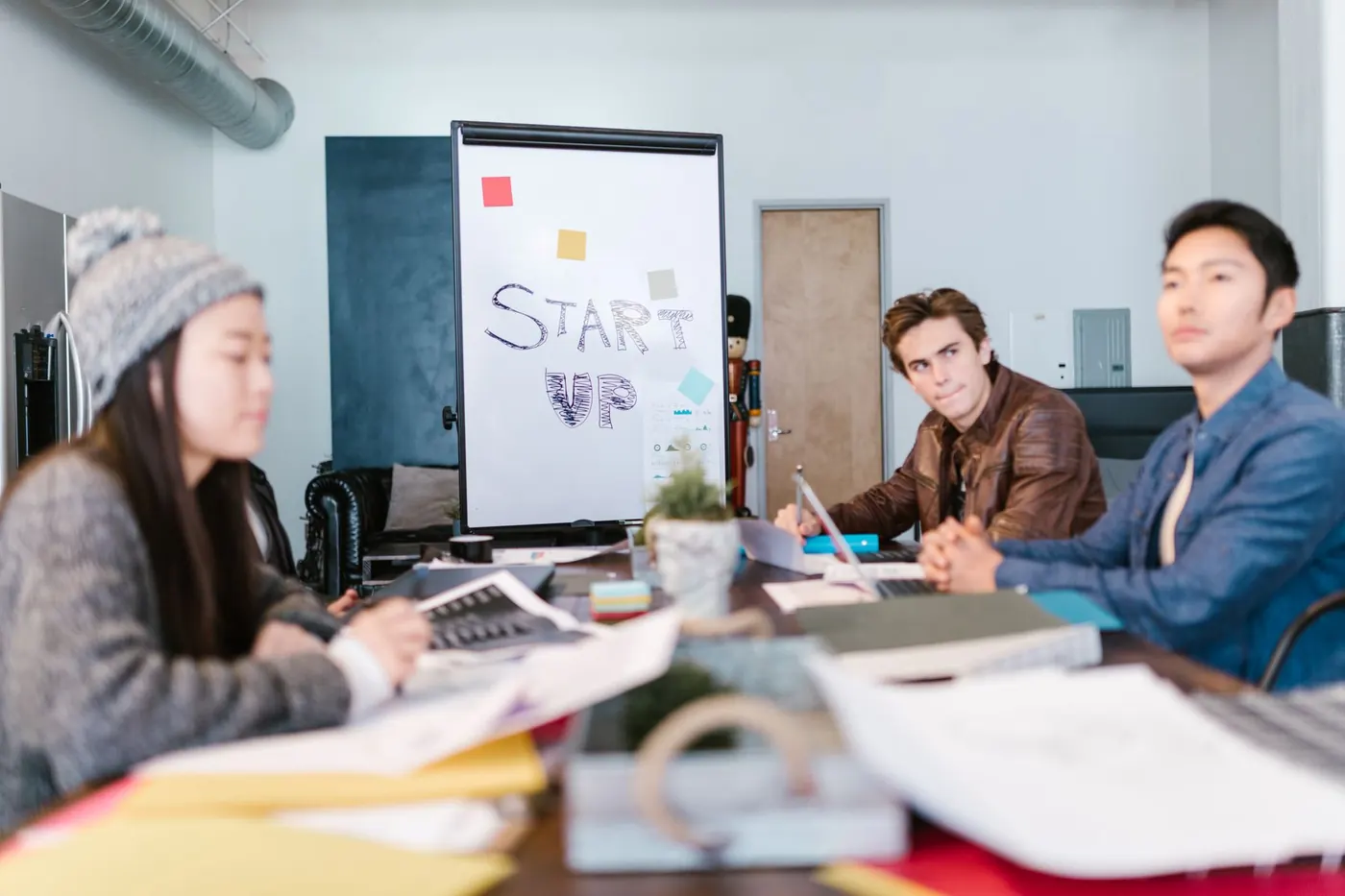 Small startup team working around a table and flip chart